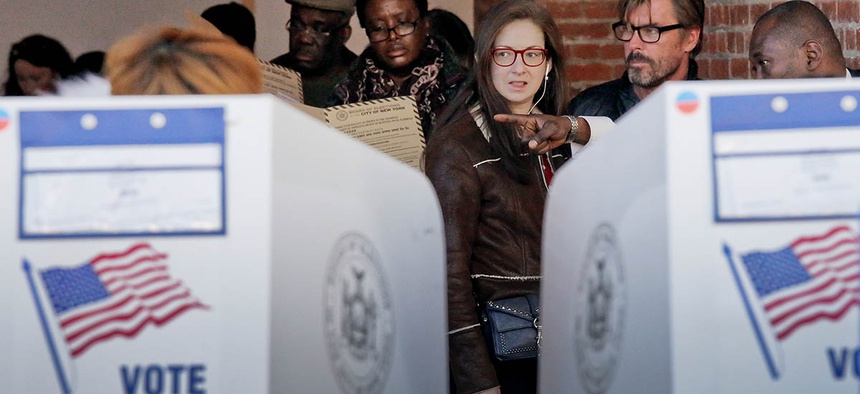 Voters are directed to empty booths to mark their ballots at the Brooklyn Museum polling site, Tuesday Nov. 8, 2016, in Brooklyn, N.Y.