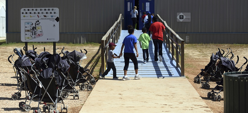 Immigrants walk into a building at South Texas Family Residential Center in Dilley, Texas.