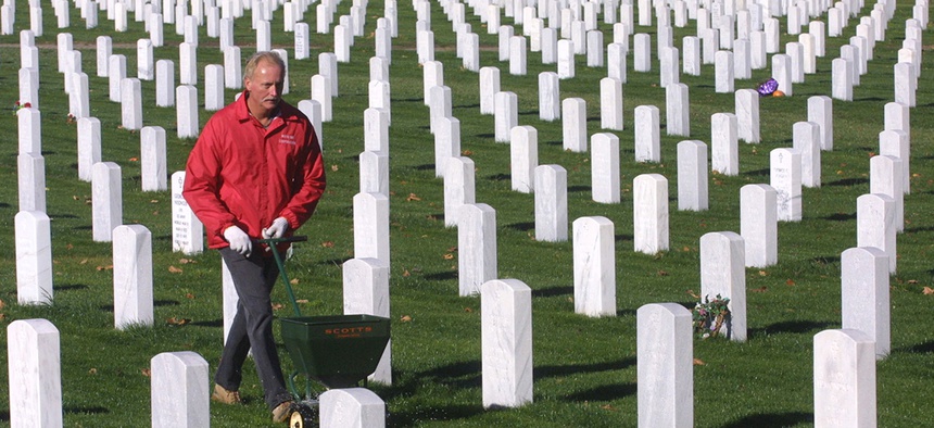 Tim Descit, an Army veteran, spreads fertilizer on the grounds of the National Cemetery at the Dayton, Ohio Veterans Administration grounds.