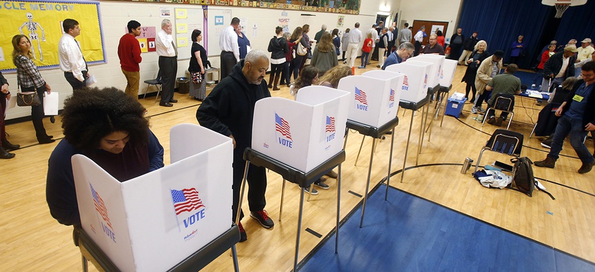 Voters fill out their ballots and wait in long lines to vote in Short Pump, Va., Tuesday, Nov. 6, 2018.