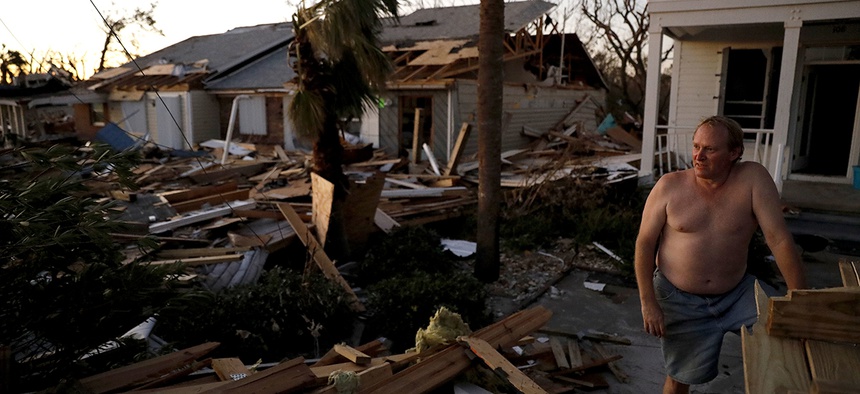 Dave Mullins looks out over the damage in front of his home, seen in background left, where he rode out hurricane Michael in Mexico Beach, Fla., Friday, Oct. 12, 2018.
