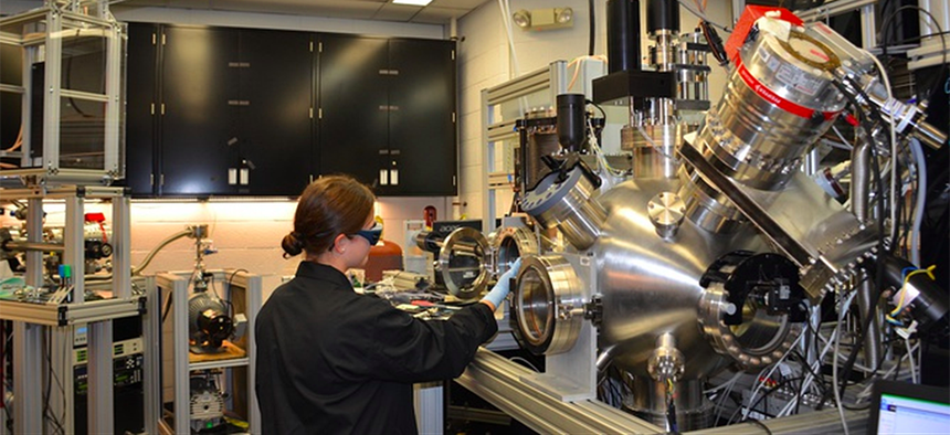Ashley Wissel, Purdue University undergraduate student, works with the pulsed laser deposition chamber in the Materials and Manufacturing Directorate. This is used to study growth of thin layers of material at low temperatures.