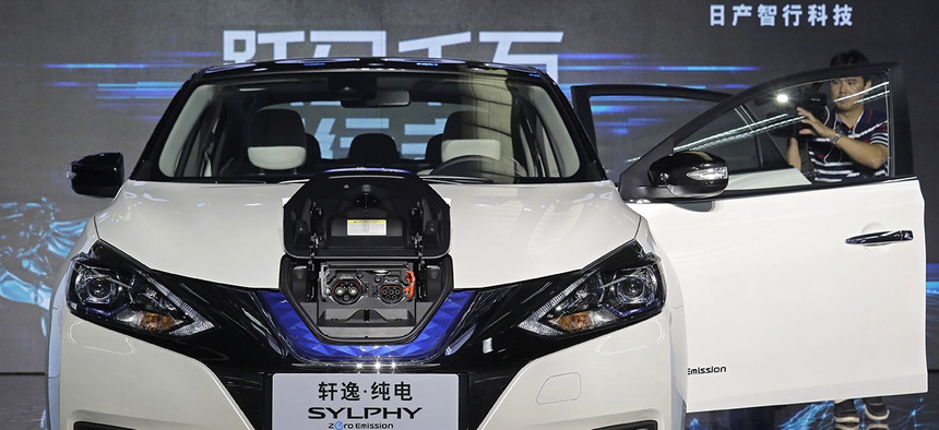 A cameraman takes video of a Nissan Sylphy Zero Emission, the Nissan's first all-electric vehicle built in China, at the Nissan factory in Guangzhou, Guangdong province, China.