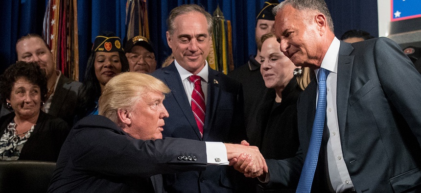 Before signing a bill, President Donald Trump shakes hands with Isaac Perlmutter, CEO of Marvel, in Washington, DC.
