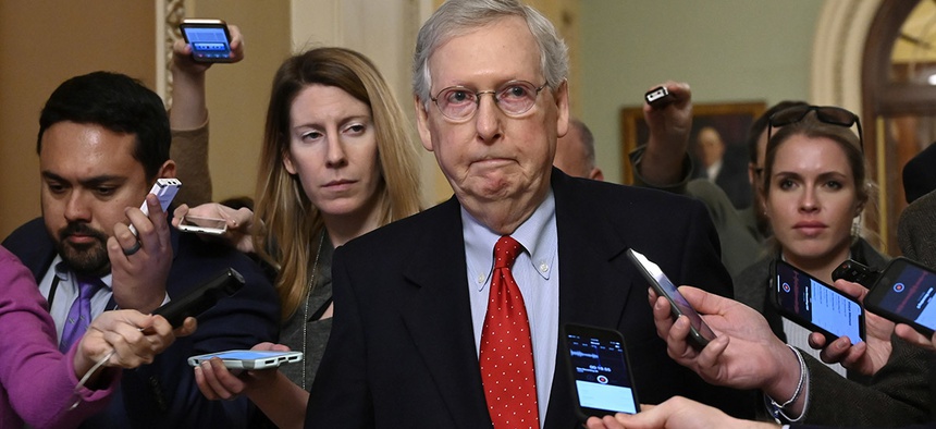 Senate Majority Leader Mitch McConnell of Ky., center, talks with reporters as he walks on Capitol Hill in Washington, Wednesday, Jan. 2, 2019, after returning from a meeting with President Donald Trump at the White House.