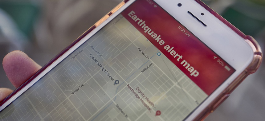 A mobile phone customer looks at an earthquake warning application on their phone in Los Angeles on Thursday, Jan. 3, 2019.