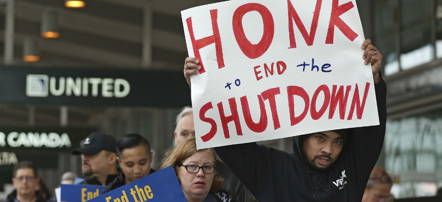 More than two dozen federal employees and supporters demonstrate at the Sacramento International Airport calling for lawmakers to end the partial government shutdown.