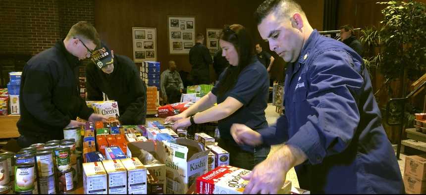 Members of the Coast Guard stock a pantry that was created to help hundreds of civilian and non-civilian employees to help makes ends meet during the partial federal government shutdown.