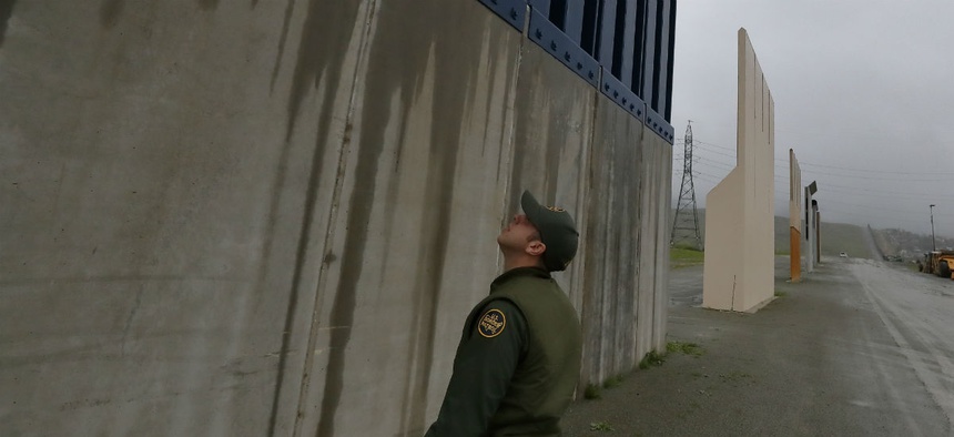 A Border Patrol agent walks towards prototypes for a border wall Feb. 5 in San Diego.