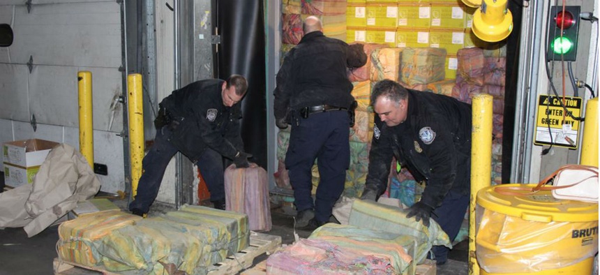 Customs agents unloading a truck containing 3,200 pounds of cocaine in 60 packages, where it was seized at the Port of New York/Newark, in Newark, N.J.