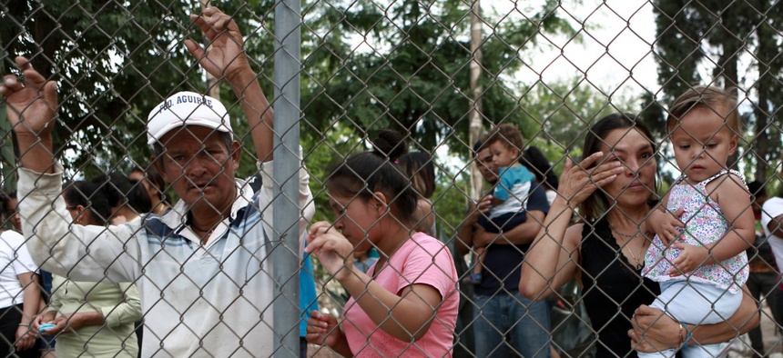 Central American migrants watch fellow migrants board busses as they voluntarily return to their countries, in Ciudad Juarez, Mexico, Tuesday, July 2, 2019.