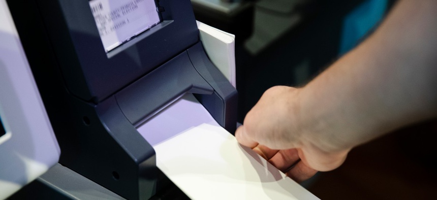 In this June 13, 2019, photo, Steve Marcinkus, an Investigator with the Office of the City Commissioners, demonstrates the ExpressVote XL voting machine at the Reading Terminal Market in Philadelphia.
