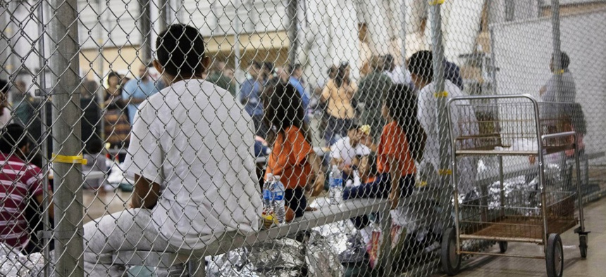In this June 17, 2018 file photo provided by Customs and Border Protection, people who've been taken into custody related to cases of illegal entry into the United States sit in a facility in McAllen, Texas.