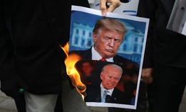 Protesters burn pictures of the U.S. President Donald Trump, top, and the President-elect Joe Biden in a gathering in front of Iranian Foreign Ministry on Nov. 28, a day after the killing of Iranian scientist Mohsen Fakhrizadeh.